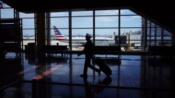 A flight crew member walks in a terminal of Reagan National Airport in Arlington, Virginia on March 17, 2020. - The coronavirus outbreak has transformed the US virtually overnight from a place of boundless consumerism to one suddenly constrained by nesting and social distancing.The crisis tests all retailers, leading to temporary store closures at companies like Apple and Nike, manic buying of food staples at supermarkets and big-box stores like Walmart even as many stores remain open for business -- albeit in a weirdly anemic consumer environment. (Photo by Mandel Ngan/AFP/Getty Images)