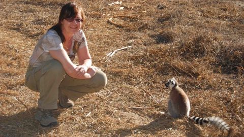 Michelle Sauther poses next to a ring-tailed lemur. 