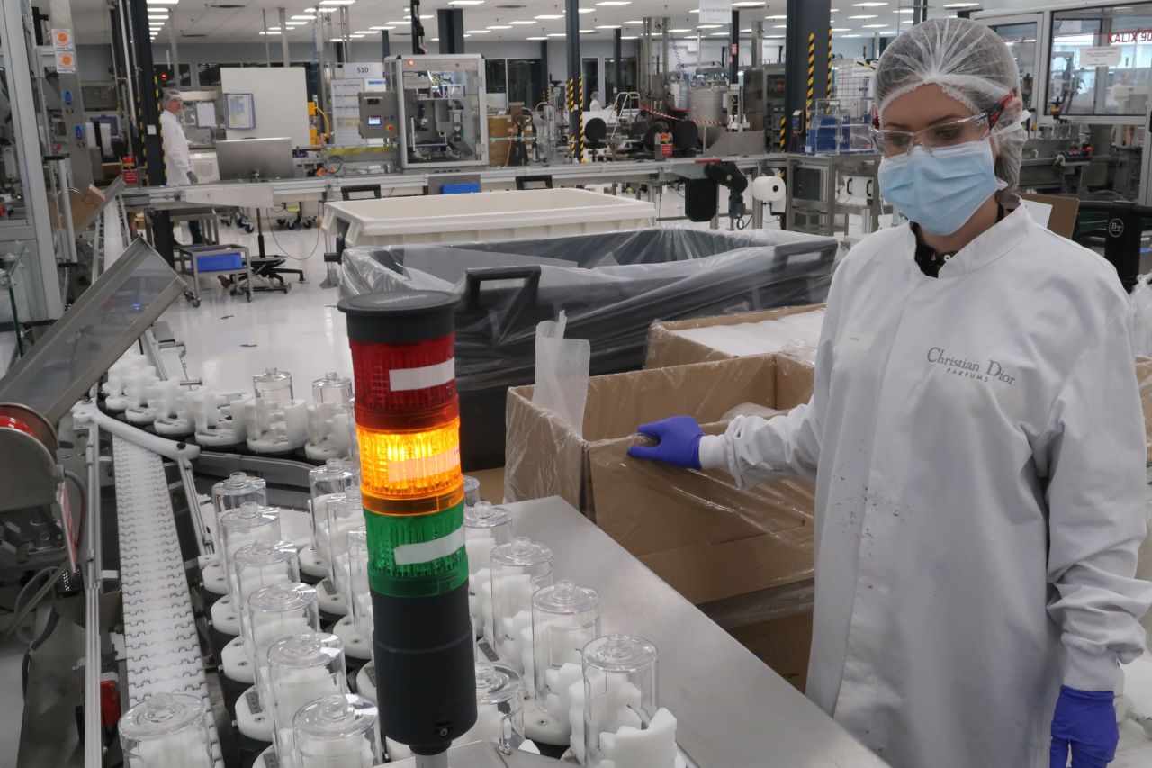 A Christian Dior factory worker on the assembly line for hand sanitizer