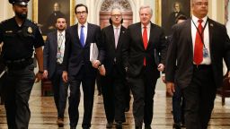 Treasury Secretary Steven Mnuchin, left, accompanied by White House Legislative Affairs Director Eric Ueland and acting White House chief of staff Mark Meadows, walks to the offices of Senate Majority Leader Mitch McConnell of Ky. on Capitol Hill in Washington, Tuesday, March 24, 2020.