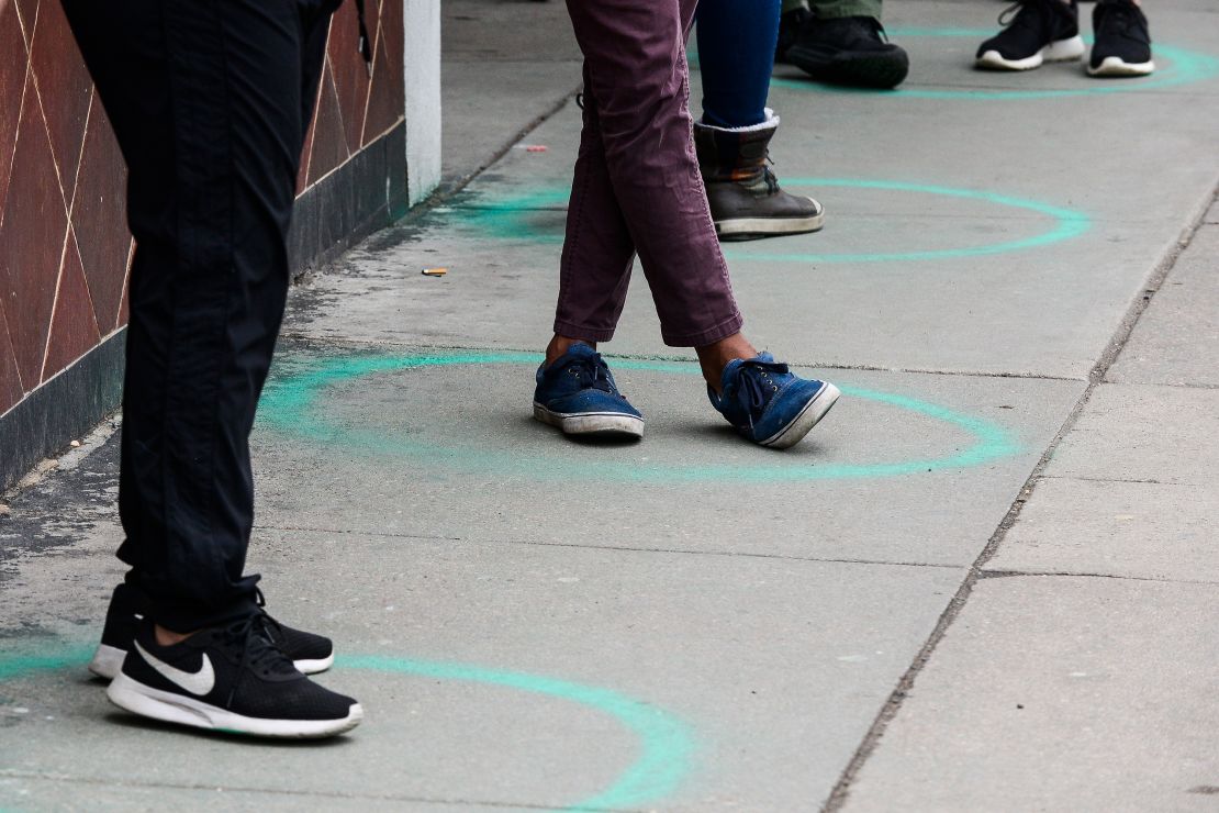 People stand in freshly painted circles, six-feet-apart, as they wait in a two-hour line on March 23, 2020 in Denver, Colorado.