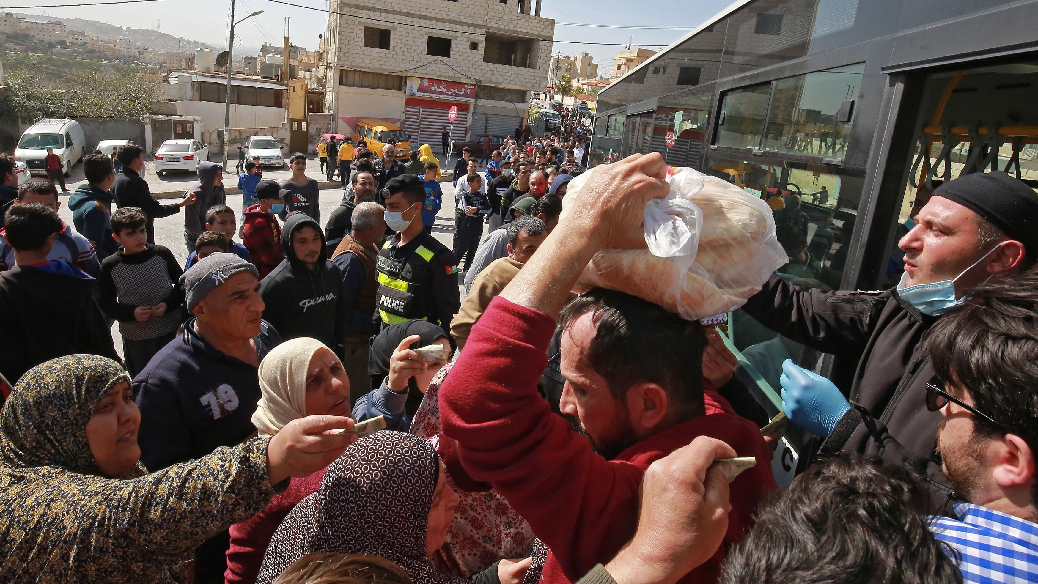 People queue to buy subsidised bread from a municipal bus in the Marka suburb of Amman on Tuesday.