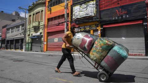 A street vendor walks along an empty popular shopping street in downtown Sao Paulo during its lockdown.