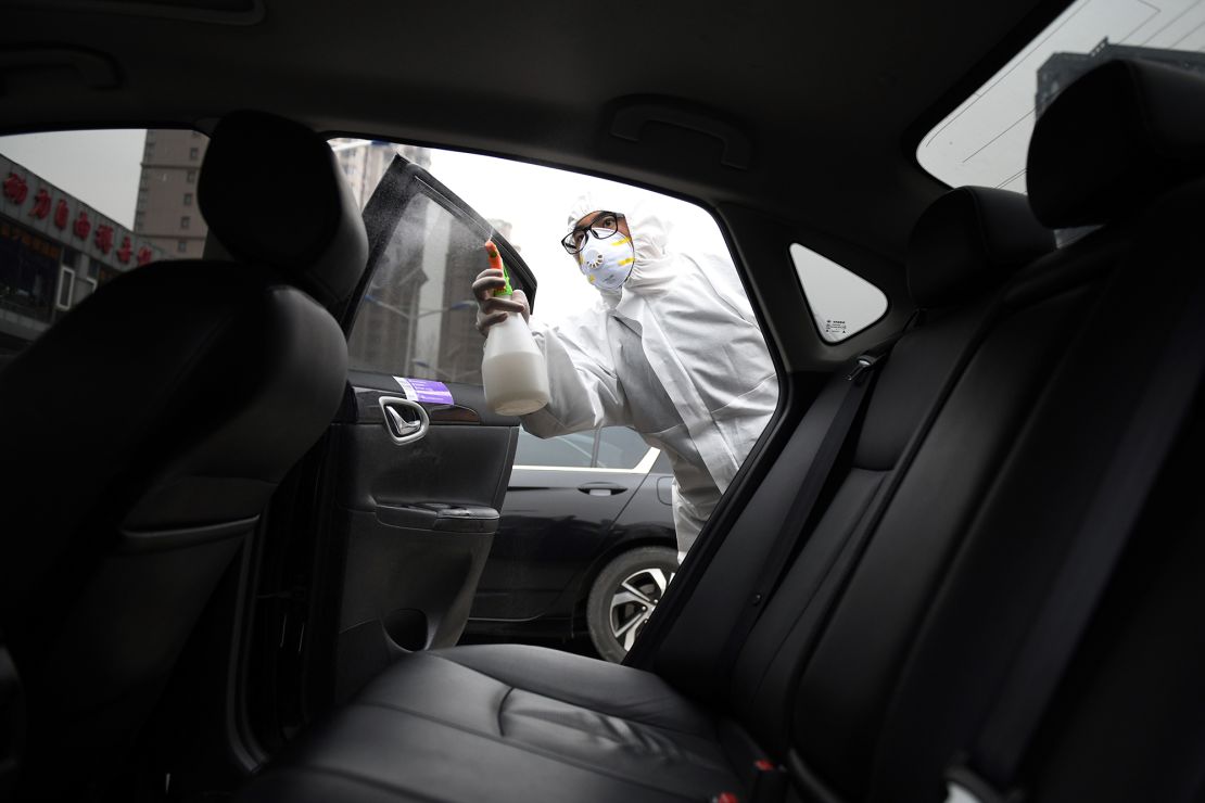 A worker wears protective clothing as he disinfects a car for Chinese ride hailing company Didi in Beijing in February. 