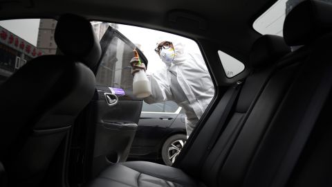 A worker wears protective clothing as he disinfects a car for Chinese ride hailing company Didi in Beijing in February. 