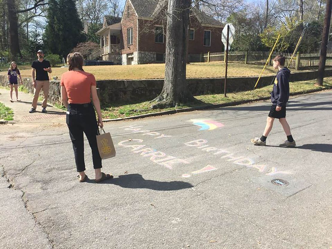 Friends draw in chalk on the street to wish Carrie Crespino a happy birthday.