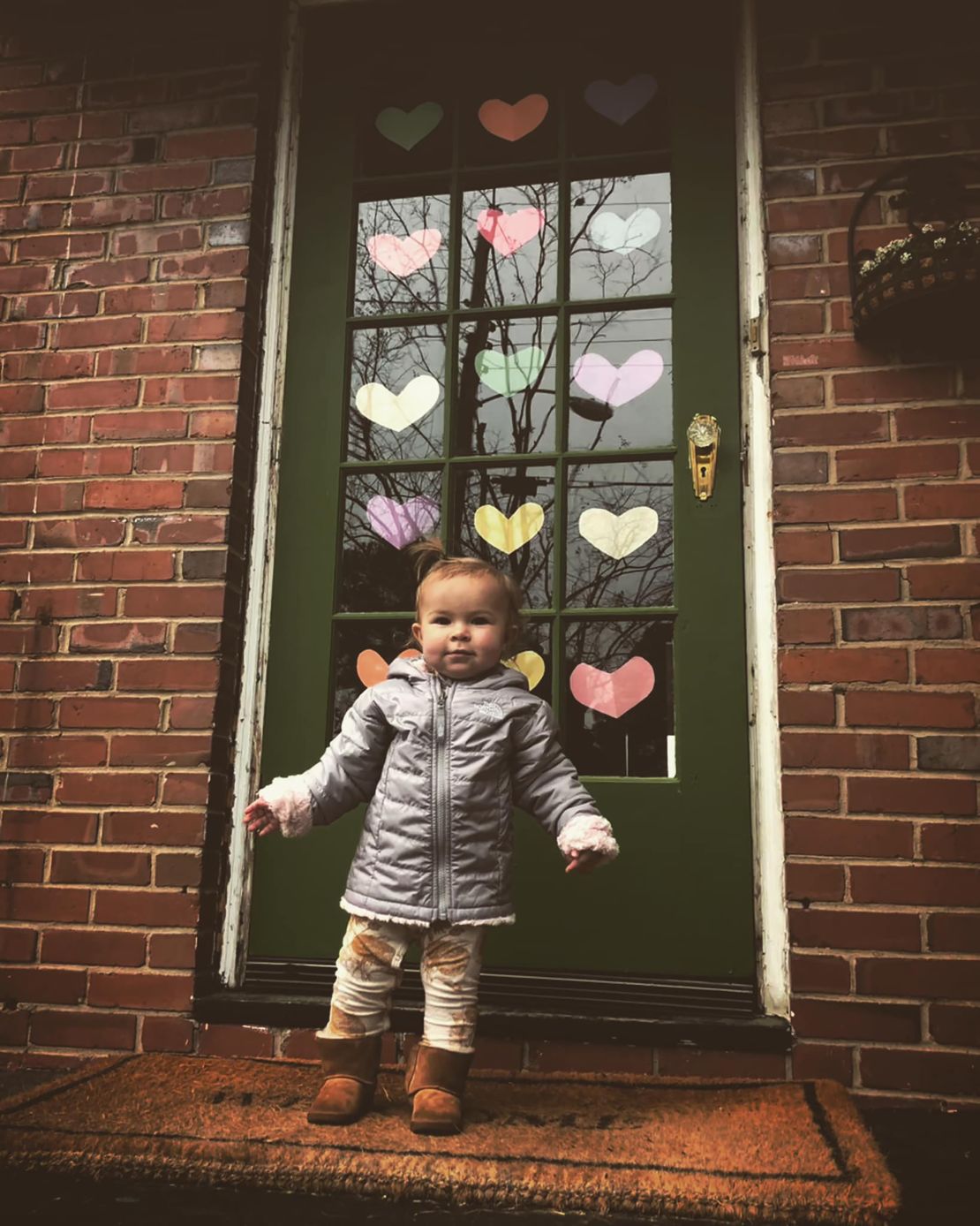 Nora Siebels stands outside her front door decked out in paper hearts in Norfolk, Virginia.