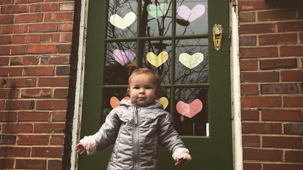 Nora Siebels stands outside her front door decked out in paper hearts in Norfolk, Virginia.