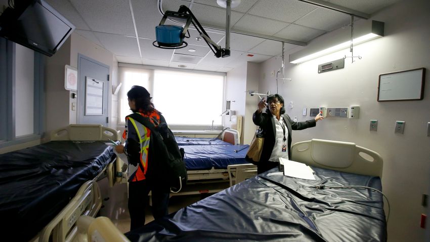 Susie McCann, right, of the Arizona health department, assess a room in the emergency area with a member of the U.S. Army Corps of Engineers as they tour the currently closed St. Luke's Medical Center hospital to see the viability of reopening the facility for possible future use due to the coronavirus Wednesday, March 25, 2020, in Phoenix. (AP Photo/Ross D. Franklin)