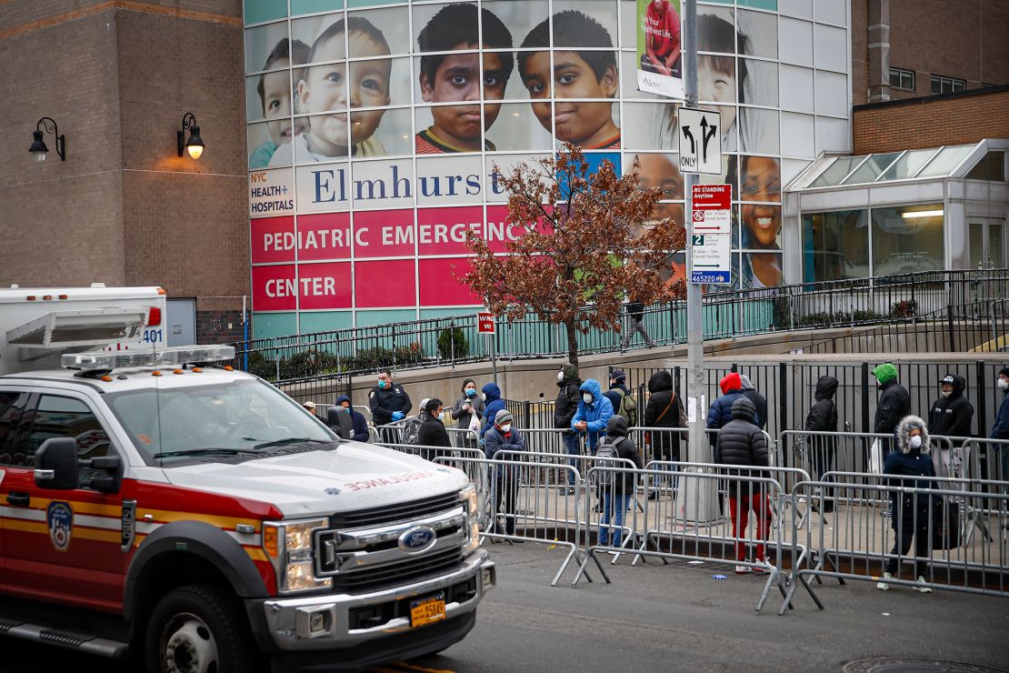 Patients wearing personal protective equipment stand on line while maintaining social distancing before entering a COVID-19 testing site at Elmhurst Hospital Center, on March 25, 2020, in New York.