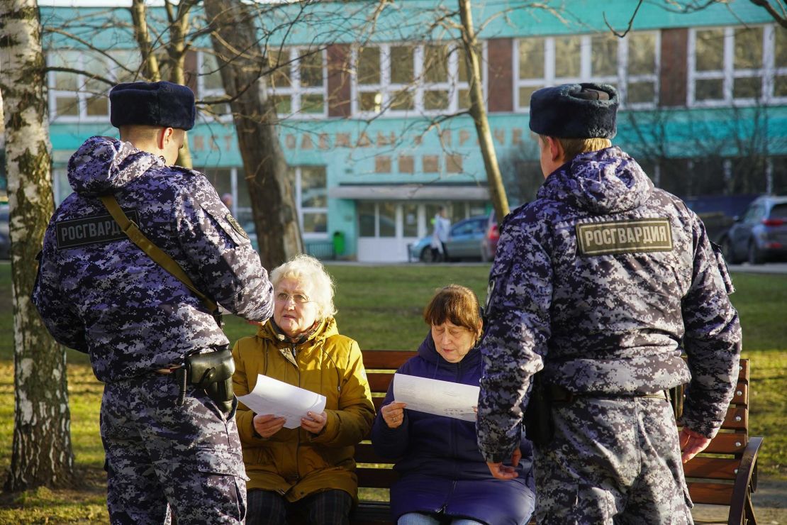 Russian Rosguardia (National Guard) soldiers speak to pensioners in Moscow, as the city ordered residents over 65 and those suffering from chronic conditions to stay home for 19 days.