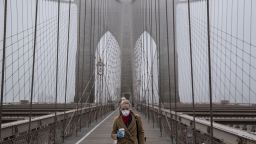 NEW YORK, NY - MARCH 20: A woman wearing a mask walks the Brooklyn Bridge in the midst of the coronavirus (COVID-19) outbreak  on March 20, 2020 in New York City. The economic situation in the city continued to decline as New York Gov Andrew Cuomo ordered all nonessential businesses to keep all their workers at home and New York weighed a shelter in place order for the entire city. (Photo by Victor J. Blue/Getty Images)