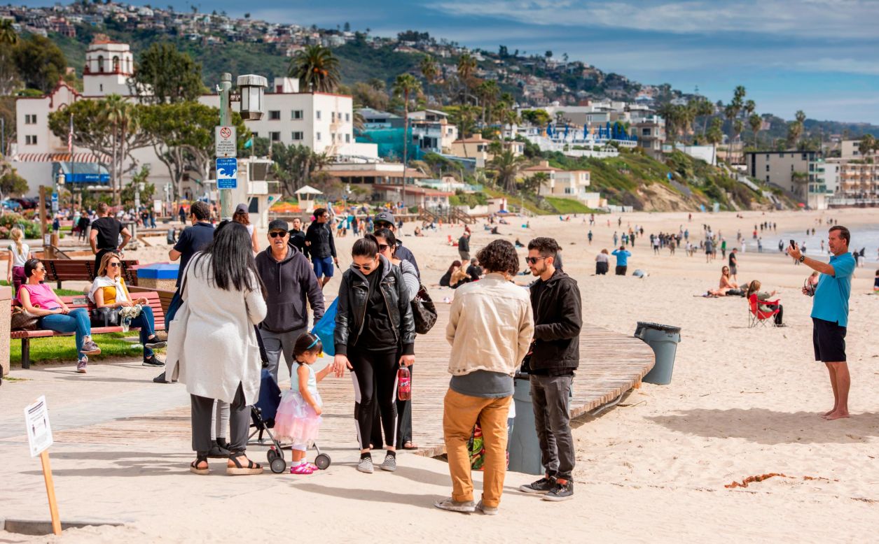 People gather on the boardwalk in Laguna Beach, California, on Sunday, March 22. <a href="https://www.cnn.com/2020/03/23/us/california-stay-at-home-beach-goers/index.html" target="_blank">Crowds descended on California beaches, hiking trails and parks</a> that weekend in open defiance of a state order to shelter in place.
