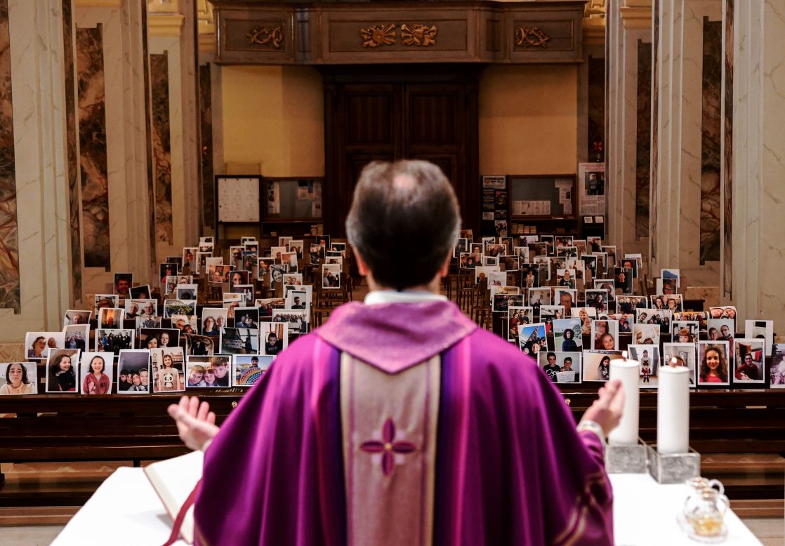 Giuseppe Corbari holds Sunday Mass in front of photographs sent in by his congregation members in Giussano, Italy, on March 22. Many religious services are being streamed online so that people can worship while still maintaining their distance from others.