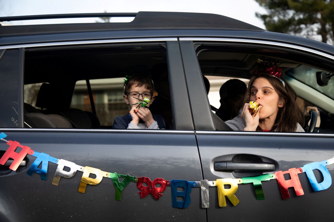 Dana Baer and her son Jacob wish Avery Slutsky a happy sixth birthday from their car in West Bloomfield Township, Michigan, on Tuesday, March 24. The drive-by birthday celebration was held to maintain social distancing and prevent the spread of the coronavirus.