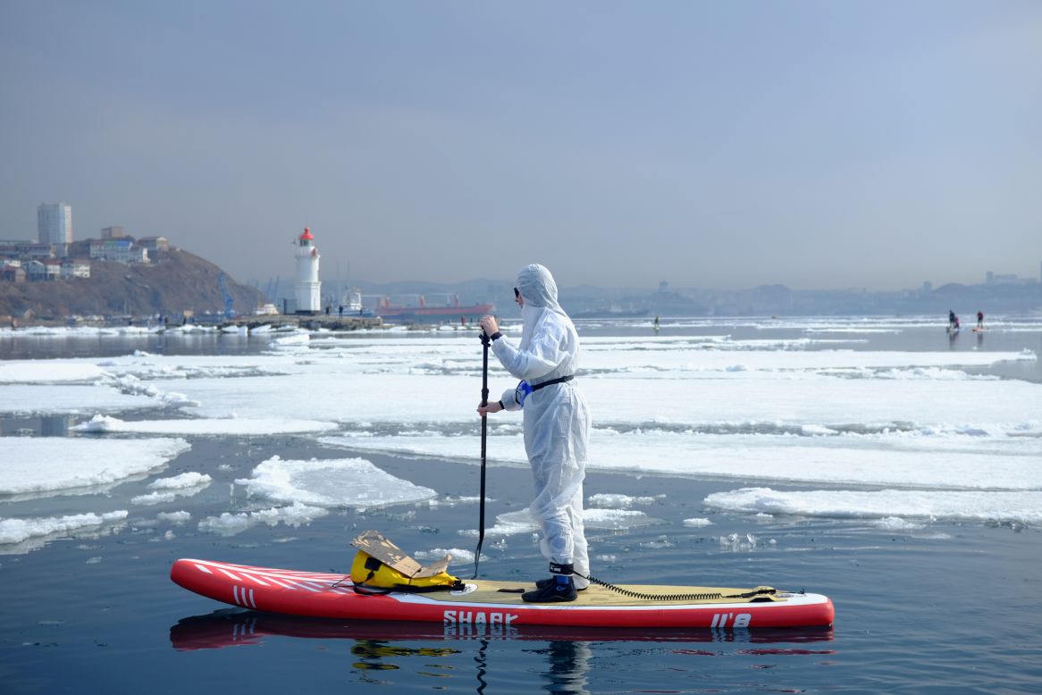 A paddleboarder in Vladivostok, Russia, wears a protective suit at an event marking the opening of the paddleboarding season on Saturday, March 21. The suit was worn to show support for those fighting the coronavirus.