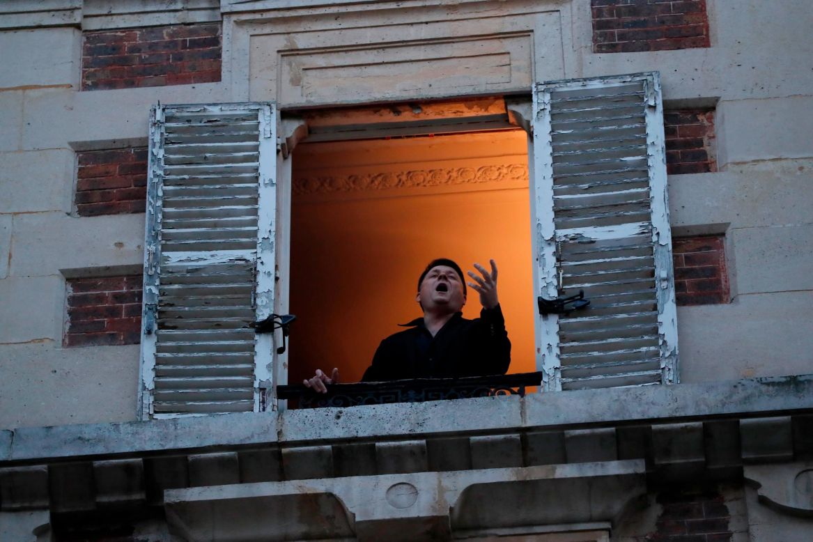 Opera singer Stephane Senechal sings for his neighbors from his apartment window in Paris on Tuesday, March 24.