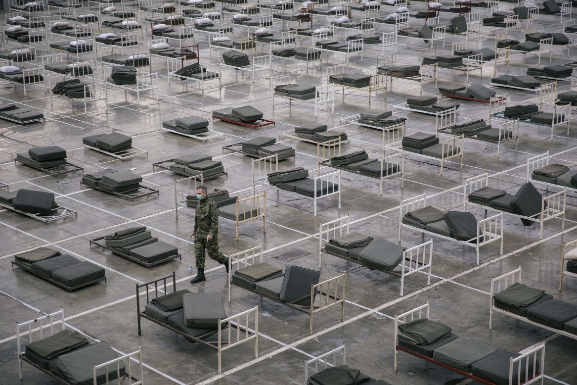 A Serbian soldier walks among beds that were set up at the Belgrade Fair to accommodate coronavirus patients on Tuesday, March 24.