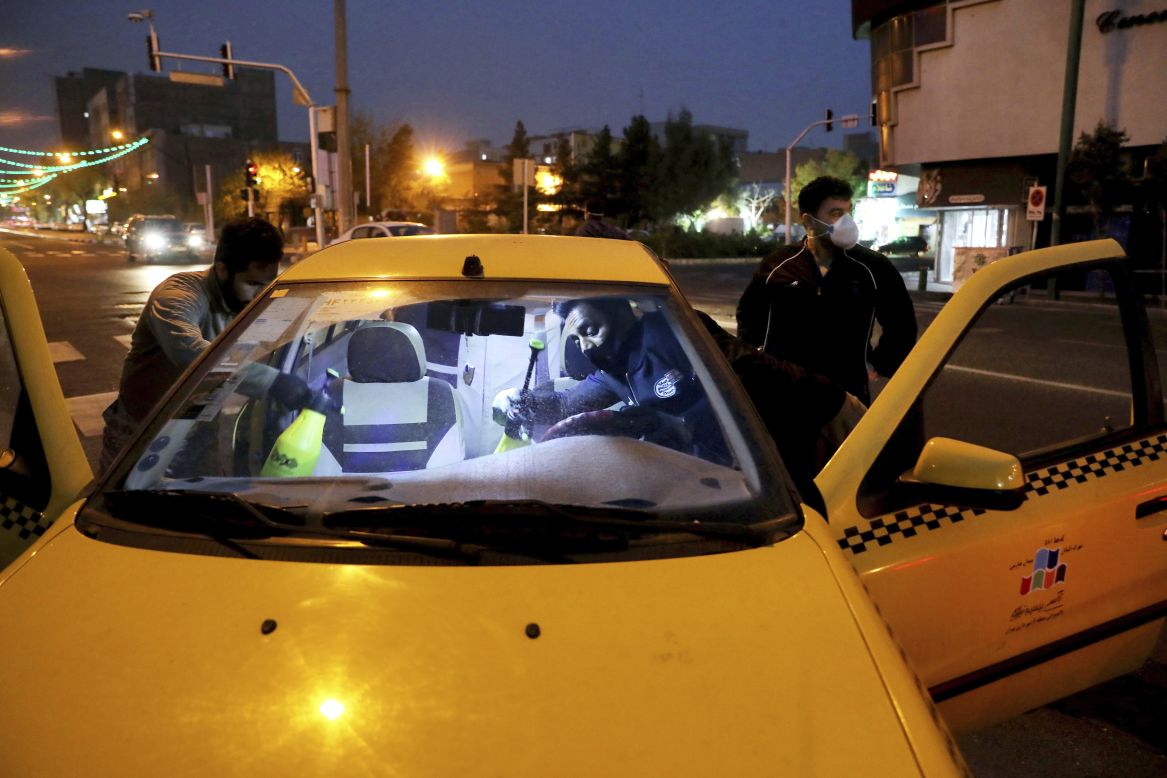 Members of Iran's Revolutionary Guard disinfect cars in Tehran on Wednesday, March 25.