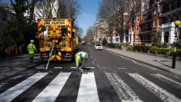 LONDON, ENGLAND - MARCH 24: A Highways Maintenance team takes advantage of the COVID-19 coronavirus lockdown and quiet streets to re-paint the iconic Abbey Road crossing on March 24, 2020 in London, England. The Beatles made the pedestrian crossing famous after featuring a photograph of the group walking on it, near to Abbey Road Studios. The album and connected artwork celebrated its fiftieth anniversary last year. British Prime Minister, Boris Johnson, announced strict lockdown measures urging people to stay at home and only leave the house for basic food shopping, exercise once a day and essential travel to and from work. The Coronavirus (COVID-19) pandemic has spread to at least 182 countries, claiming over 10,000 lives and infecting hundreds of thousands more. (Photo by Leon Neal/Getty Images)