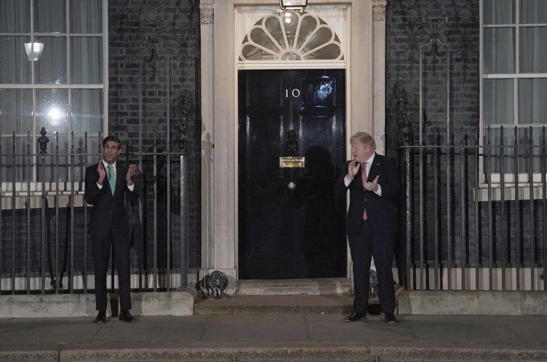 Boris Johnson, right, taking part in a national applause with his chancellor, Rishi Sunak.