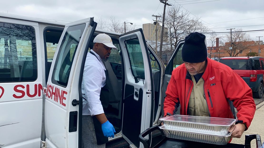 Hardy helps volunteer load meals into a van. 