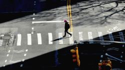 A person crosses the street on March 27, 2020 in New York City. - The US now has more COVID-19 infections than any other country, and a record number of newly unemployed people, as the coronavirus crisis deepens around the world. (Photo by Angela Weiss/AFP/Getty Images)