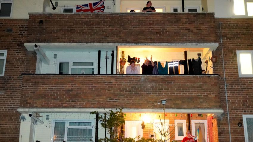 MANCHESTER,  - MARCH 26: People applaud the NHS from their balconies and gardens across the road from Wythenshawe Hospital on March 26, 2020 in Manchester, United Kingdom. The "Clap For Our Carers" campaign has been encouraging people across the U.K to take part in the nationwide round of applause from their windows, doors, balconies and gardens at 8pm to show their appreciation for the efforts of the NHS as they tackle the coronavirus (COVID-19). The coronavirus pandemic has spread to many countries across the world, claiming over 20,000 lives and infecting hundreds of thousands more. (Photo by Christopher Furlong/Getty Images)