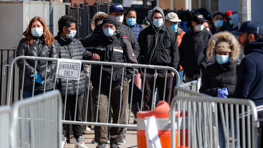 Patients wearing face masks and personal protective equipment wait on line for COVID-19 testing outside Elmhurst Hospital Center, Friday, March 27, 2020, in New York. The new coronavirus causes mild or moderate symptoms for most people, but for some, especially older adults and people with existing health problems, it can cause more severe illness or death. (AP Photo/John Minchillo)