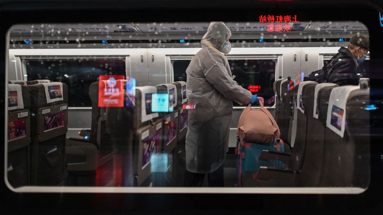 A woman wearing protective gear as a preventive measure against the COVID-19 novel coronavirus boards a train, one of the stops being Wuhan, at a station in Shanghai on March 28, 2020. - The Chinese city of 11 million people that was Ground Zero for what became the global coronavirus pandemic partly reopened on March 28, after more than two months of almost total isolation. (Photo by Hector RETAMAL / AFP) (Photo by HECTOR RETAMAL/AFP via Getty Images)