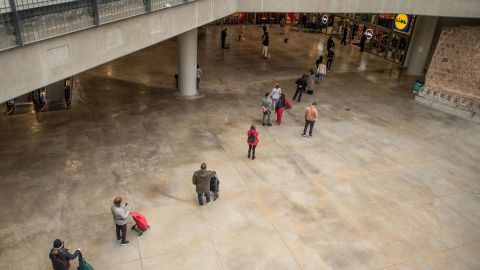 People keep their distance from each other as they wait in a supermarket queue in Barcelona on March 16.