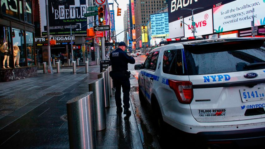 A NYPD officer patrols Times Square as rain falls on March 28, 2020 in New York City. - US President Donald Trump said on March 28, 2020 that he's considering a short-term quarantine of New York state, New Jersey, and parts of Connecticut. (Photo by Kena Betancur / AFP) (Photo by KENA BETANCUR/AFP via Getty Images)
