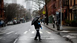 A pedestrian wearing a protective mask and protective gloves walks across an empty Dekalb Avenue, Sunday, March 29, 2020, in Brooklyn borough of New York. The new coronavirus causes mild or moderate symptoms for most people, but for some, especially older adults and people with existing health problems, it can cause more severe illness or death. 