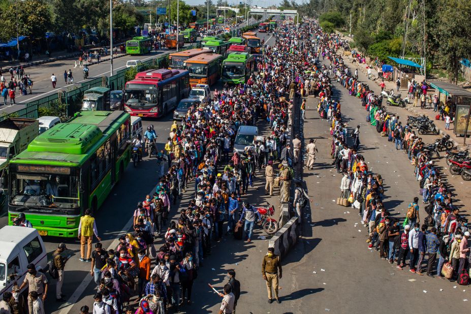 Crowds of migrant workers wait to board buses outside New Delhi.