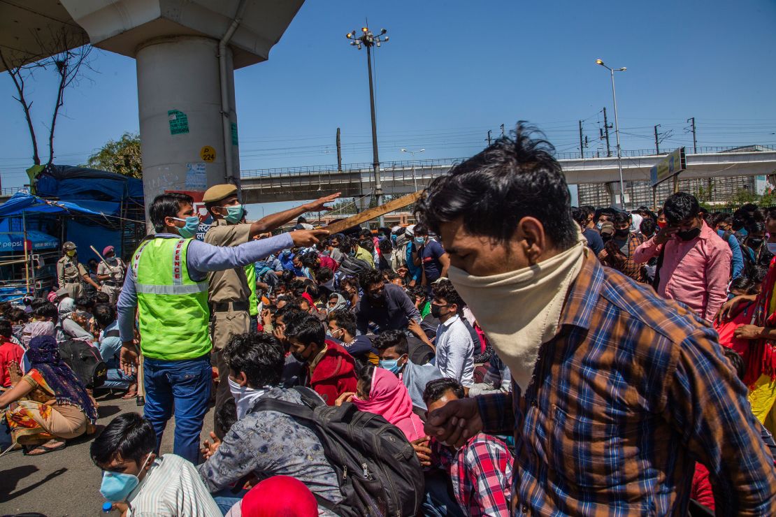 Indian migrant workers stuck in the national capital try to board buses to return to their home villages. 