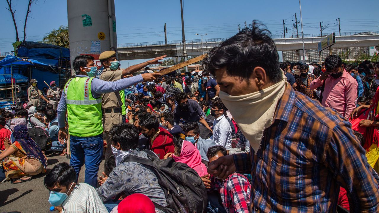 Indian migrant workers stuck in the national capital try to board buses to return to their home villages. 