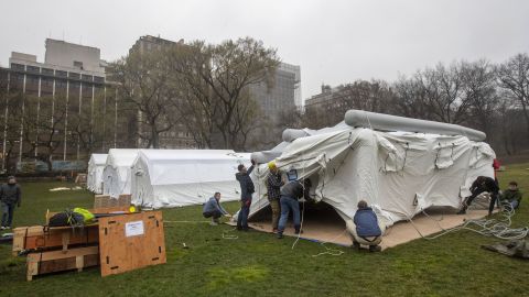 A Samaritan's Purse crew works on building an emergency field hospital equipped with a respiratory unit in New York's Central Park across from the Mount Sinai Hospital, Sunday, March 29, 2020.