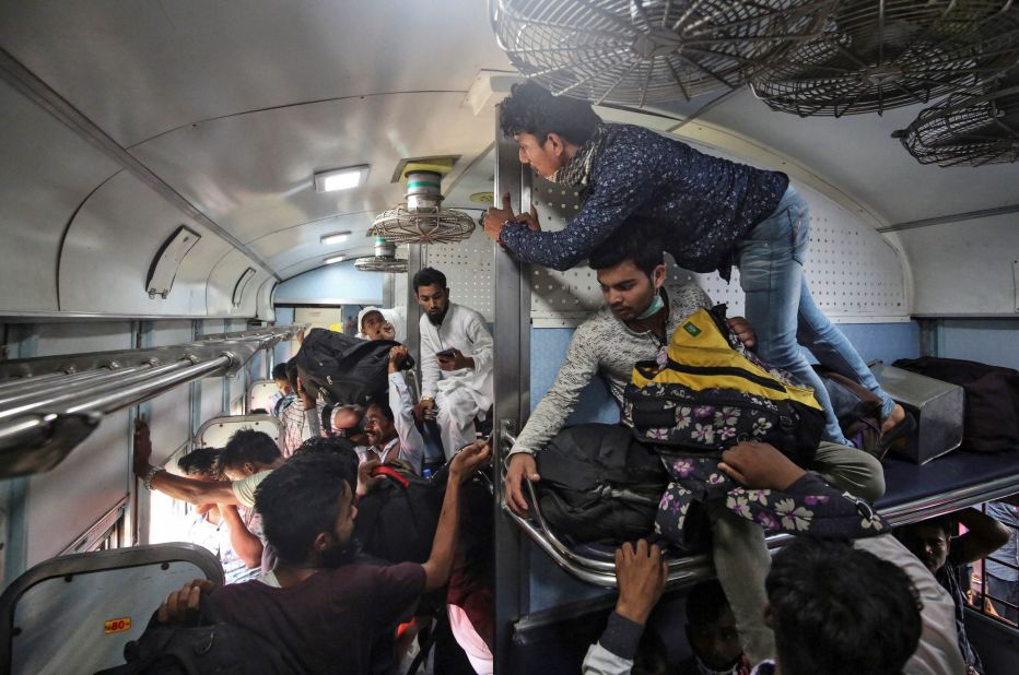 Migrant workers and their families board an overcrowded passenger train in Mumbai on March 21. Many workers had already left India's big cities before this weekend. 