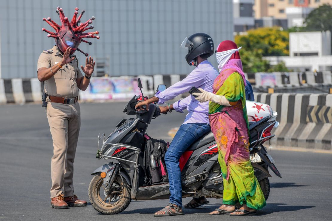 Police inspector Rajesh Babu in a coronavirus-themed helmet, talking to commuters in Chennai, India, on March 28.