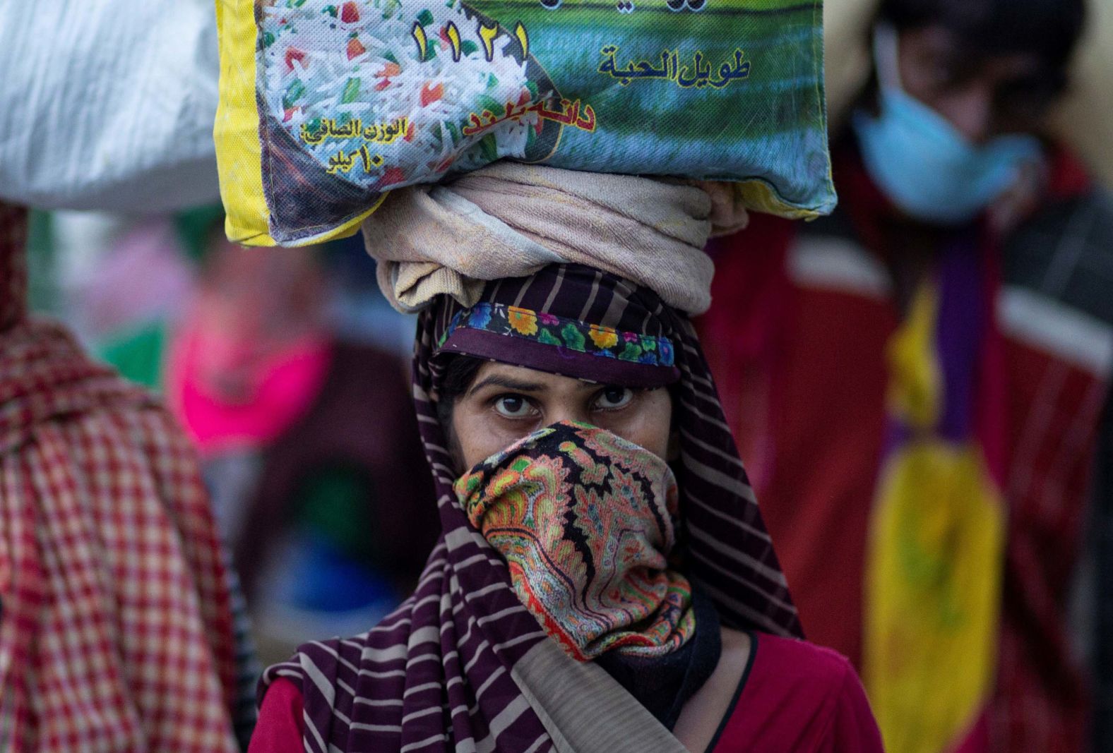 A migrant worker carries her belongings along a roadside in New Delhi.