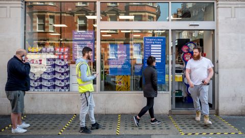 Shoppers observe social distancing in a queue outside a supermarket in central London.