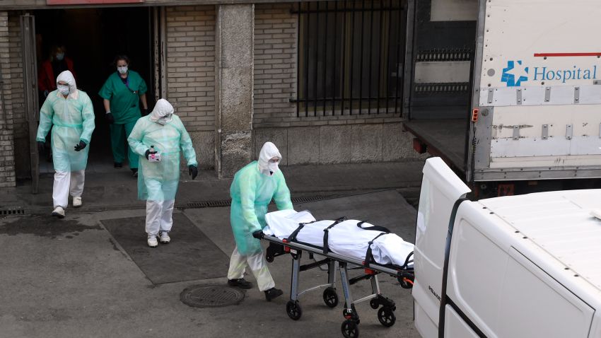 TOPSHOT - A health worker carries a body on a stretcher outside Gregorio Maranon hospital in Madrid on March 25, 2020. - Spain joined Italy today in seeing its death toll from the coronavirus epidemic surpass that of China, as more than a billion Indians joined a lockdown that has confined a third of humanity. (Photo by OSCAR DEL POZO / AFP) (Photo by OSCAR DEL POZO/AFP via Getty Images)
