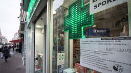This photograph taken on March 16, 2020 in Paris shows the front window of a pharmacy displaying a message summing up the precautions needed to be taken to contain the spread of the COVID-19 caused by the novel coronavirus, as well as an emergency number.