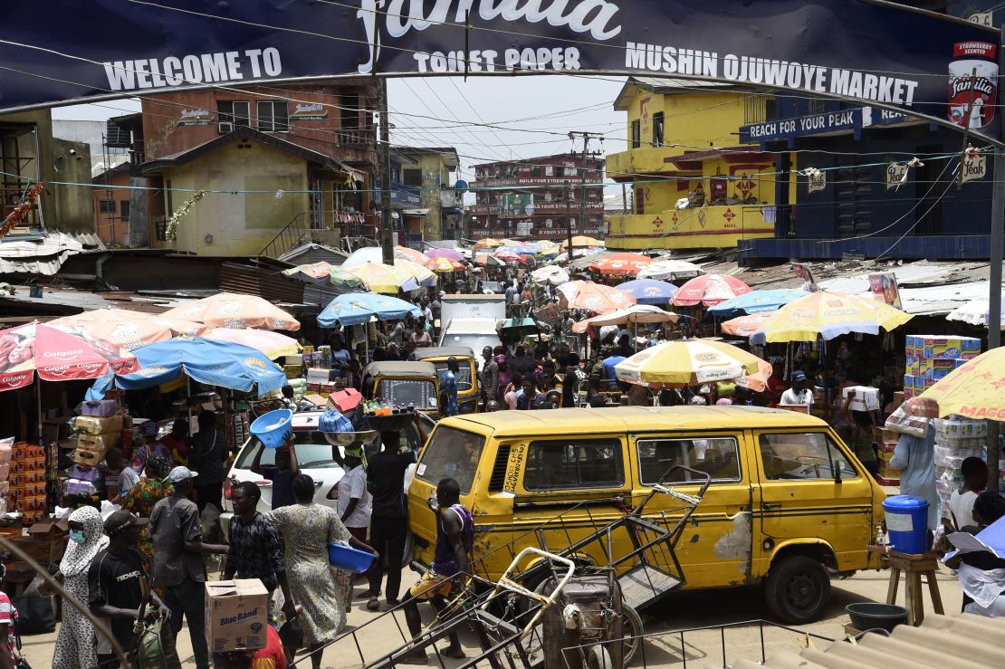 People walk in a crowded market in defiance to a social spacing order, to make last minute shopping ahead of a curfew, at the Mushin Market in Lagos. 