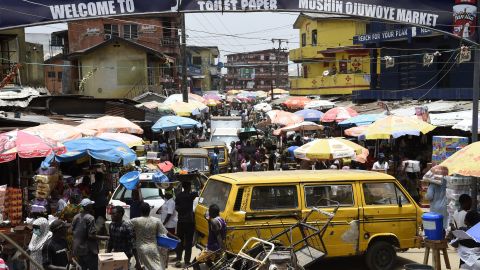People walk in a crowded market in defiance to a social spacing order, to make last minute shopping ahead of a curfew, at the Mushin Market in Lagos. 