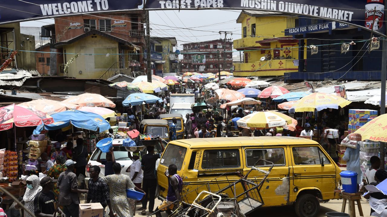 People walk in a crowded market in defiance to a social spacing order, to make last minute shopping ahead of a curfew, at the Mushin Market in Lagos.