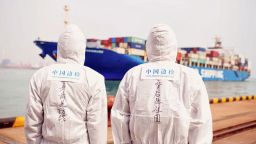 China's immigration inspection officers wearing protective suits look at a cargo ship at a port in Qingdao in China's eastern Shandong province on March 31, 2020. (Photo by STR / AFP) / China OUT (Photo by STR/AFP via Getty Images)