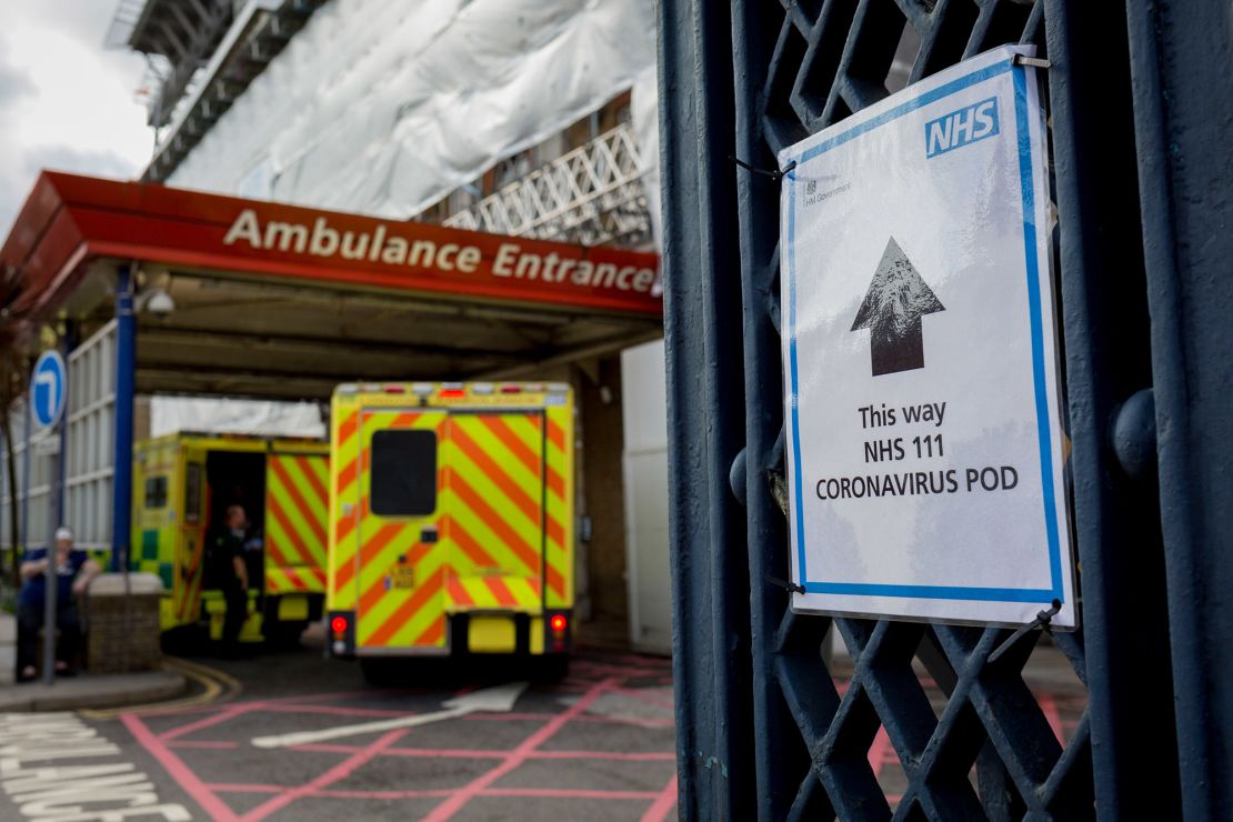 A sign points to a coronavirus testing pod, as an ambulance arrives at King's College Hospital in Camberwell, south London, on March 11.