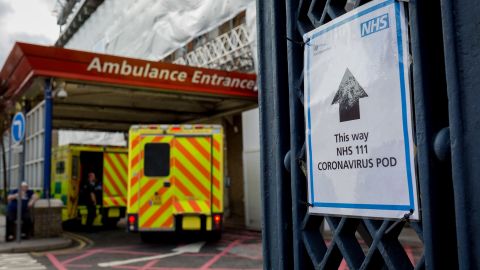 A sign points to a coronavirus testing pod, as an ambulance arrives at King's College Hospital in Camberwell, south London, on March 11.