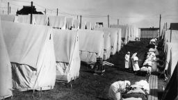 1918:  Nurses care for victims of a Spanish influenza epidemic outdoors amidst canvas tents during an outdoor fresh air cure, Lawrence, Massachusetts.  (Photo by Hulton Archive/Getty Images)